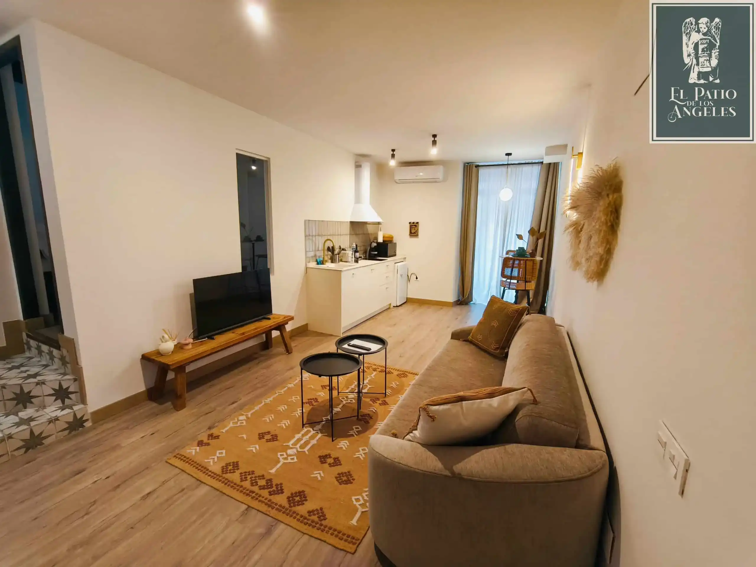 Salón moderno con cocina equipada en apartamento turístico El Patio de los Ángeles, en el centro histórico de Toledo.