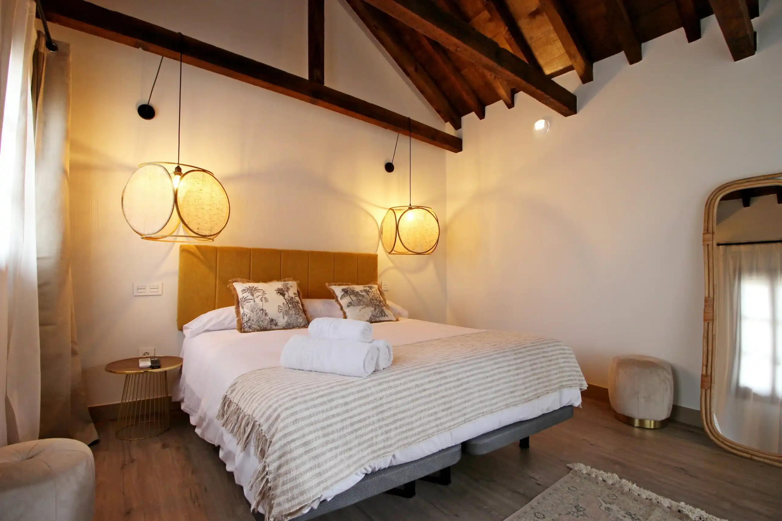 Dormitorio con cama doble y techo de madera en apartamento turístico El Patio de los Ángeles en Toledo centro.